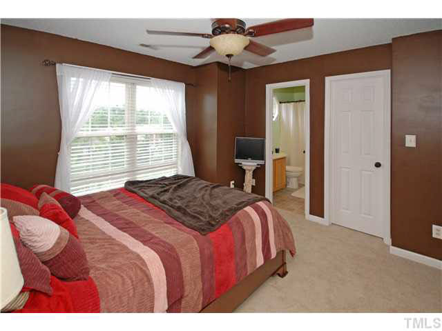 4712 Valley Stream Drive Raleigh, NC 27616 - Photo 13 of 25 a bedroom with a bed and a chandelier
