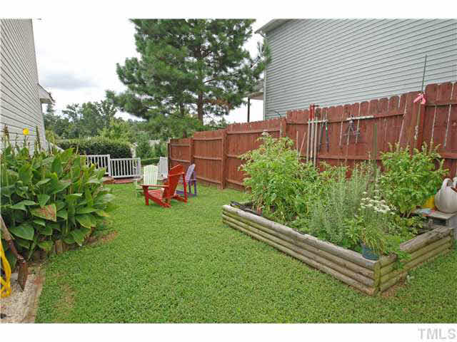 4712 Valley Stream Drive Raleigh, NC 27616 - Photo 22 of 25 a backyard of a house with a garden and plants