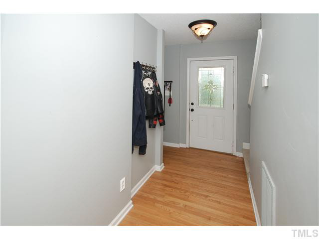 4712 Valley Stream Drive Raleigh, NC 27616 - Photo 4 of 25 a view of a hallway to a house with wooden floor