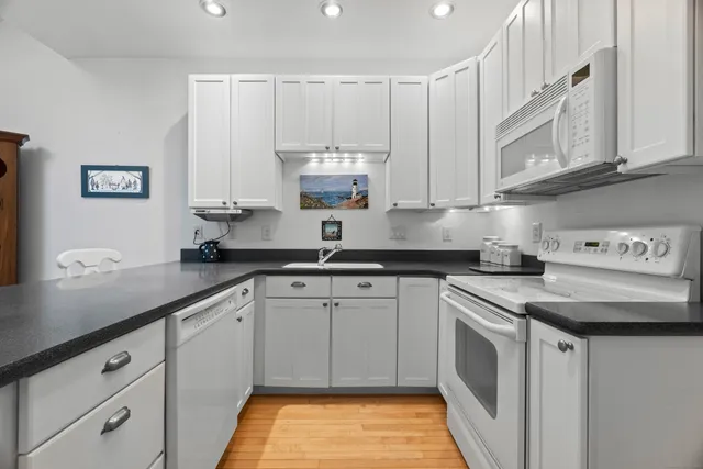 a kitchen with stainless steel appliances granite countertop a sink a stove and cabinets
