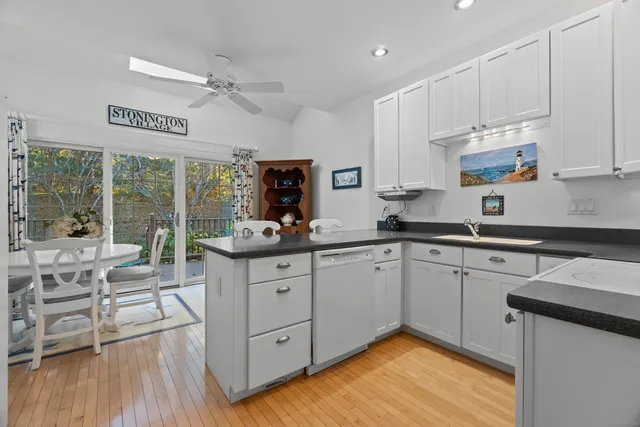 a kitchen with stainless steel appliances white cabinets a sink and a stove