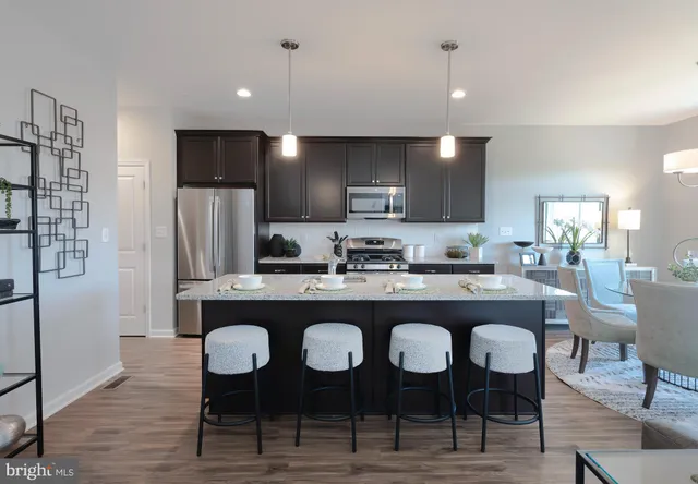 a kitchen with a dining table chairs refrigerator and cabinets