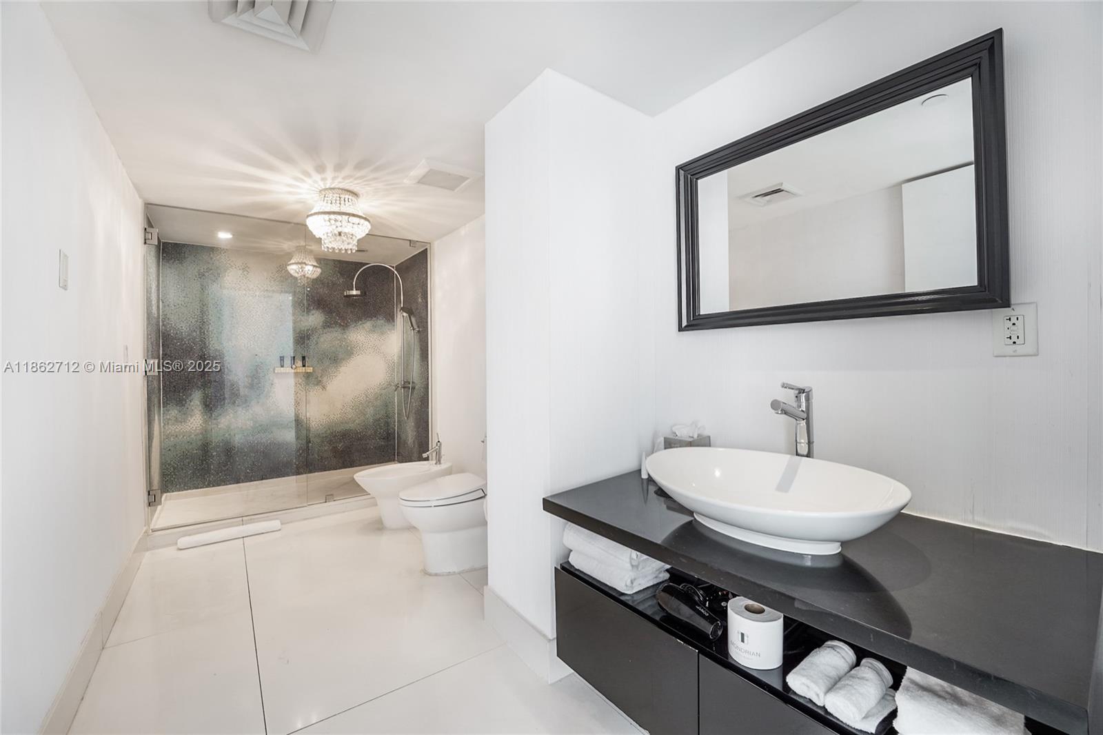 1100 West Avenue, Unit TS4 Miami Beach, FL 33139 - Photo 13 of 18 a bathroom with a toilet a sink and mirror