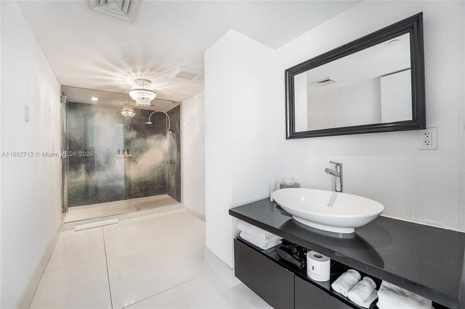 1100 West Avenue, Unit TS4 Miami Beach, FL 33139 - Photo 14 of 18 a bathroom with a sink a mirror and a shower