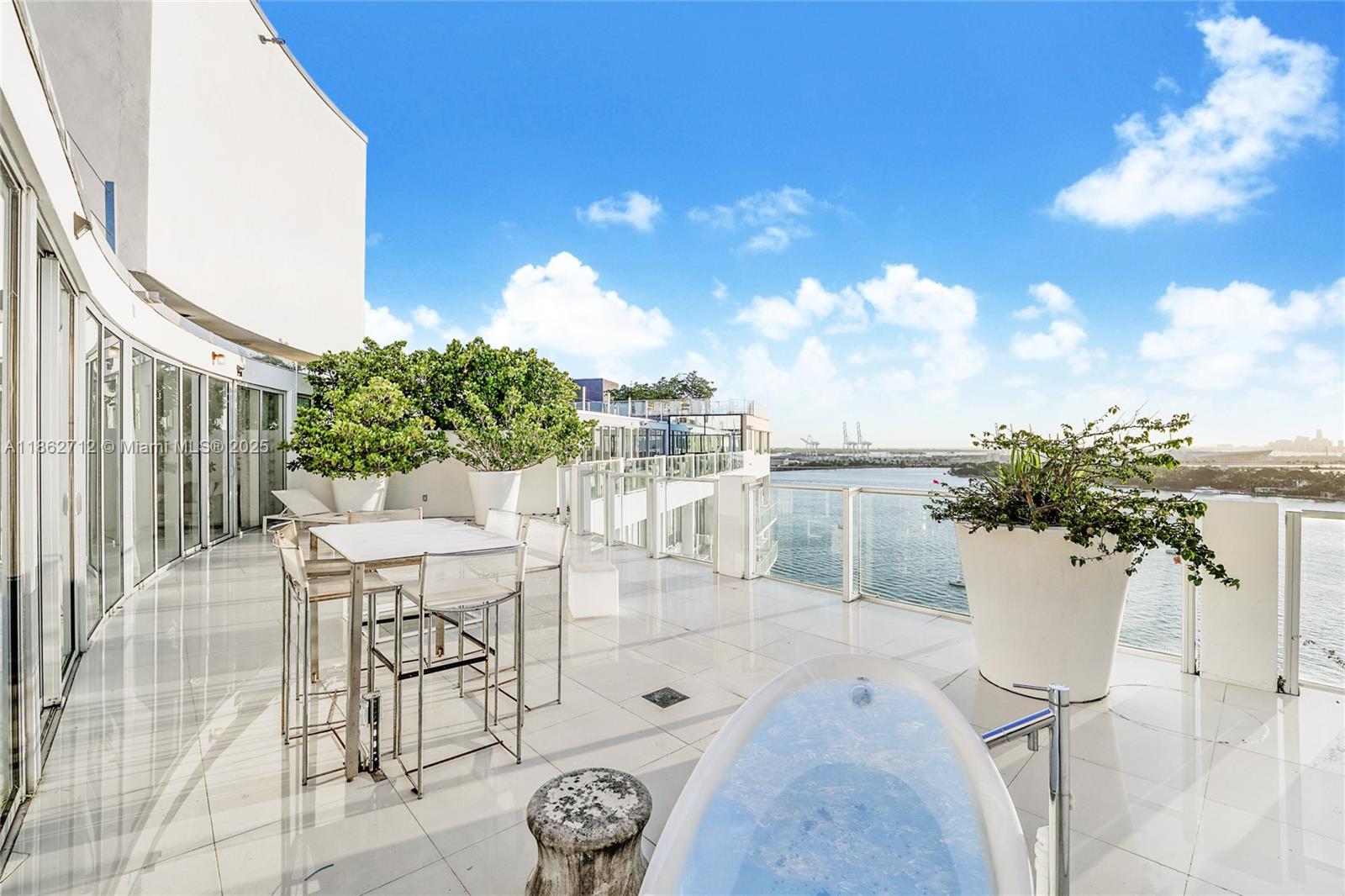 1100 West Avenue, Unit TS4 Miami Beach, FL 33139 - Photo 3 of 18 a view of a patio with table and chairs and potted plants with wooden floor