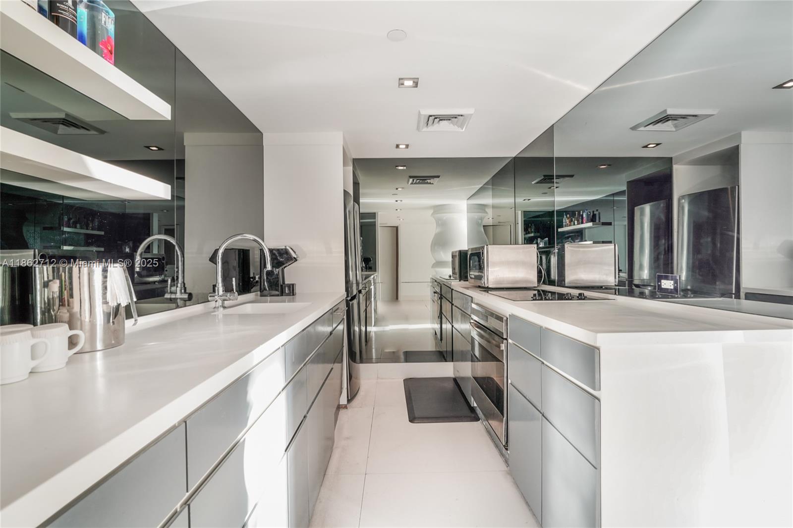 1100 West Avenue, Unit TS4 Miami Beach, FL 33139 - Photo 7 of 18 a large white kitchen with stainless steel appliances lots of counter top space and a sink