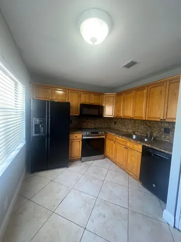 a large kitchen with a stove a sink and a refrigerator