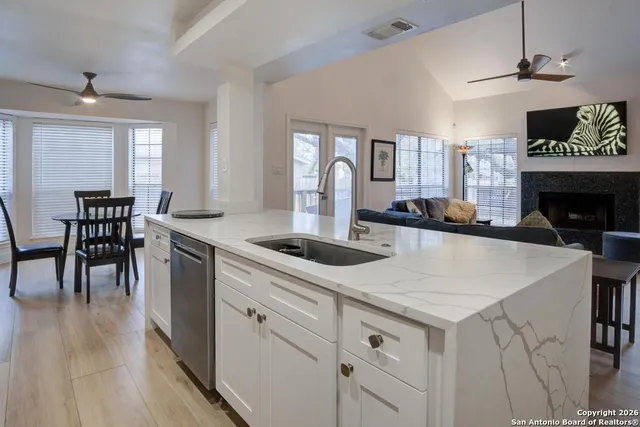 a kitchen with white cabinets and stainless steel appliances