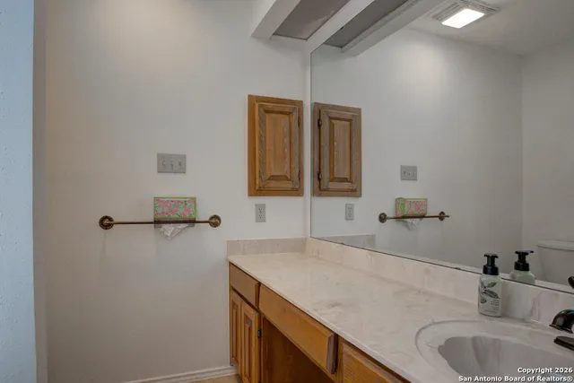 a bathroom with a granite countertop sink and a mirror