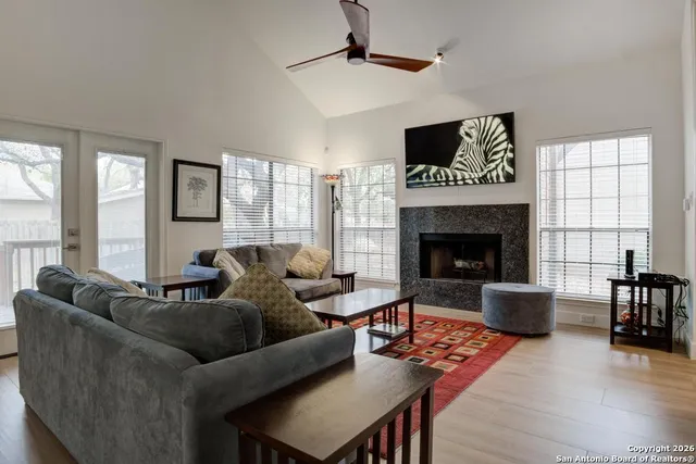 a living room with furniture a flat screen tv and a fireplace