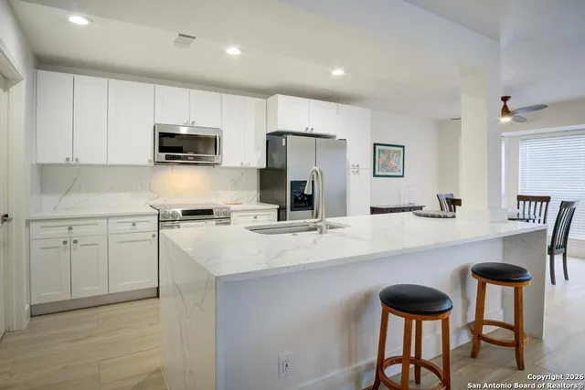 a kitchen with stainless steel appliances a sink and a refrigerator