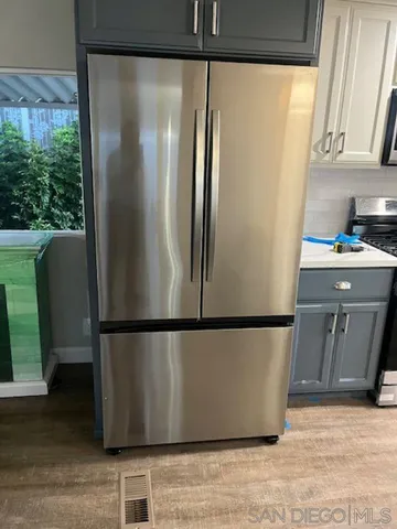 a view of a refrigerator in kitchen and wooden floor