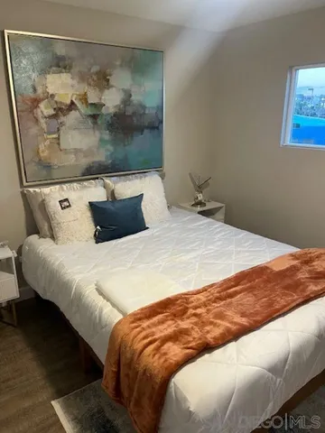 a bedroom with a bed and painting on the wall