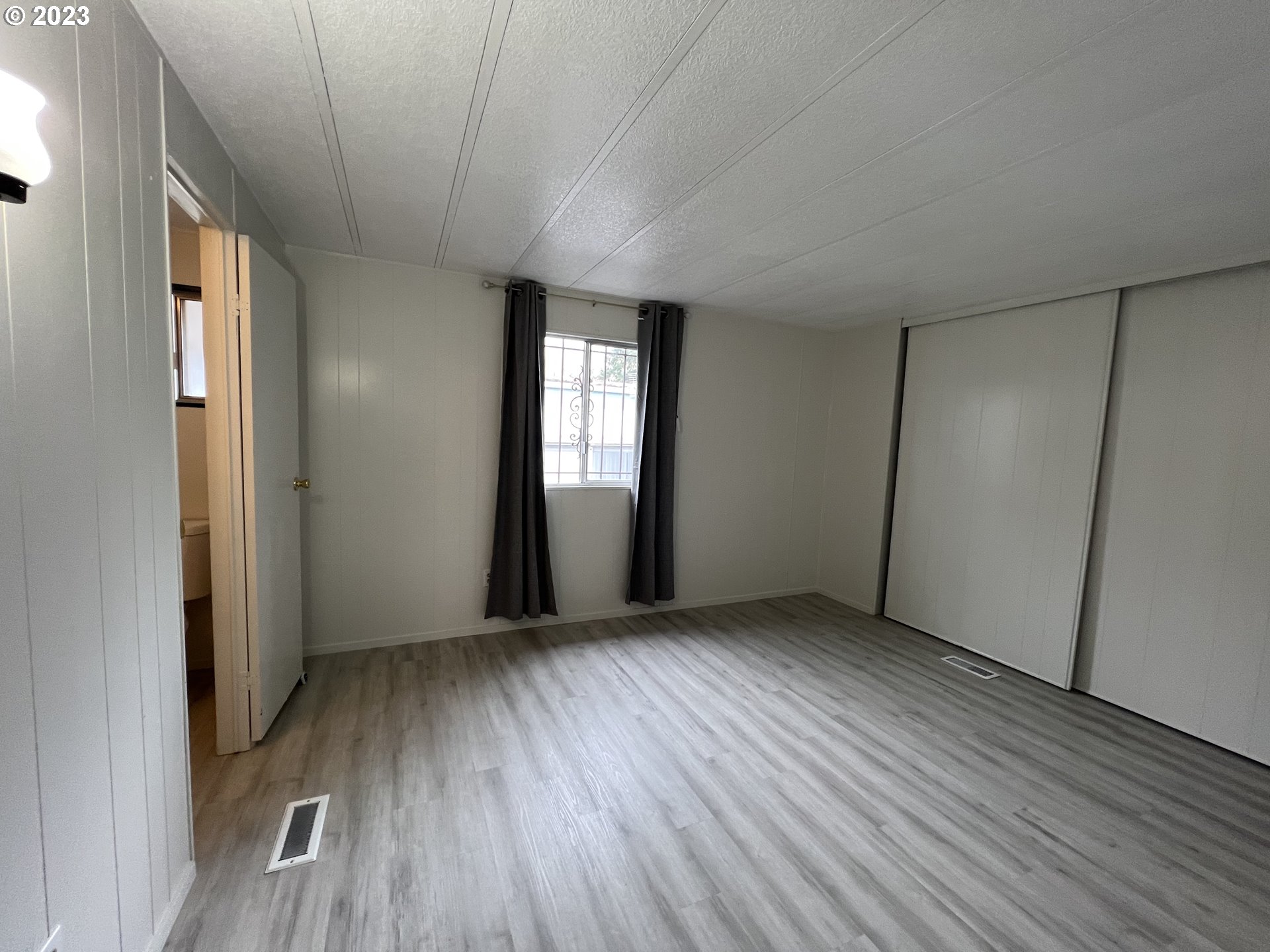 16745 Southeast Division Street, Unit 290 Portland, OR 97236 - Photo 17 of 22 an empty room with wooden floor and windows