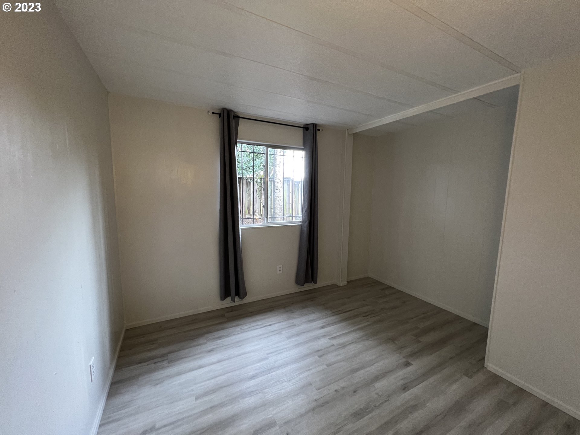 16745 Southeast Division Street, Unit 290 Portland, OR 97236 - Photo 18 of 22 an empty room with wooden floor and windows