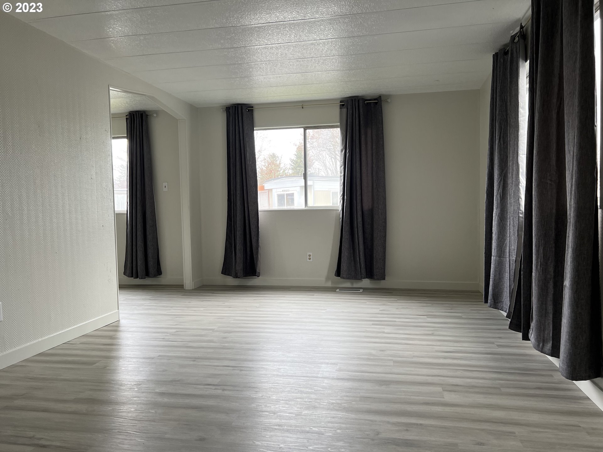 16745 Southeast Division Street, Unit 290 Portland, OR 97236 - Photo 3 of 22 an empty room with wooden floor and windows