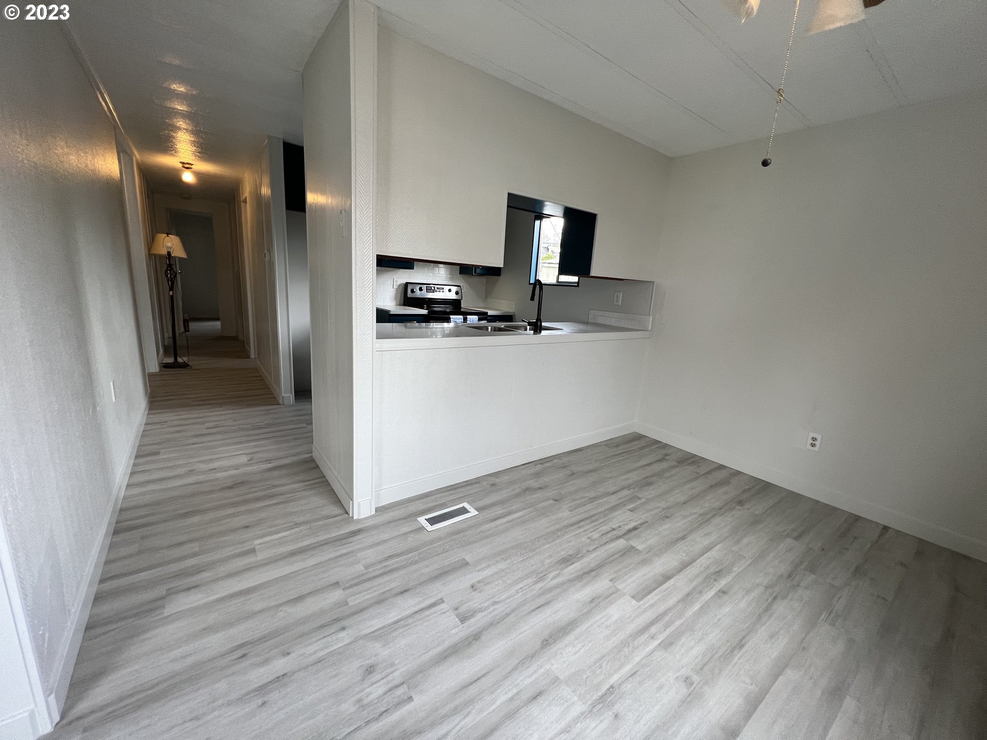 16745 Southeast Division Street, Unit 290 Portland, OR 97236 - Photo 7 of 22 a view of kitchen with wooden floor electronic appliances and window