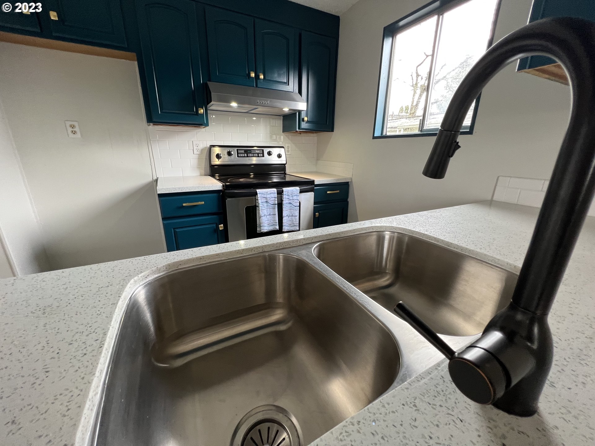 16745 Southeast Division Street, Unit 290 Portland, OR 97236 - Photo 9 of 22 a kitchen with kitchen island a stove and a sink with wooden floor