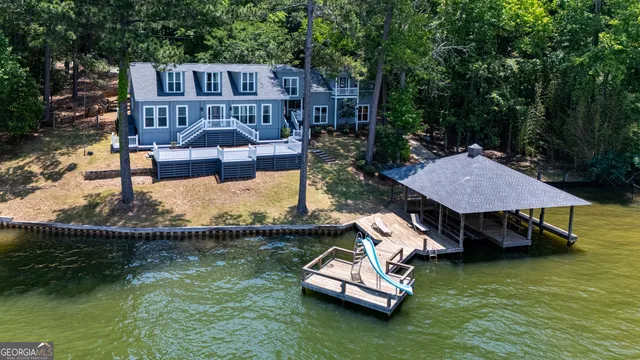 an aerial view of a house with swimming pool big yard and large trees