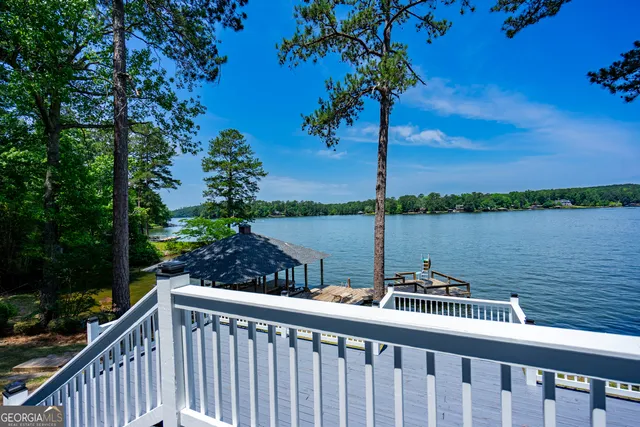 a view of a lake with lawn chairs and a table