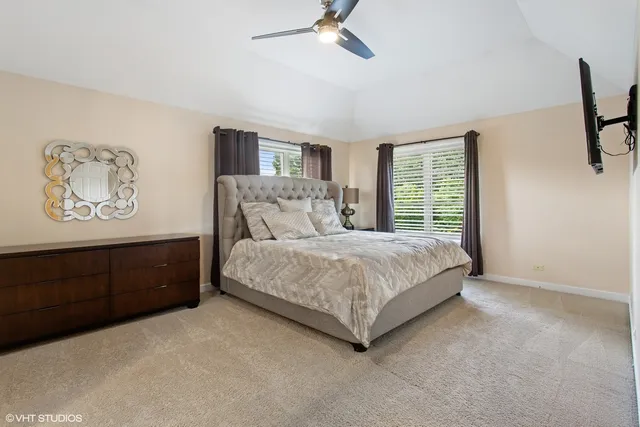 a bedroom with a bed painting on wall and a window