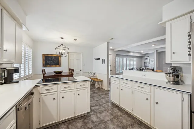 a kitchen with white cabinets sink and stove