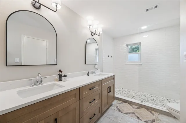 a bathroom with a double vanity sink mirror and