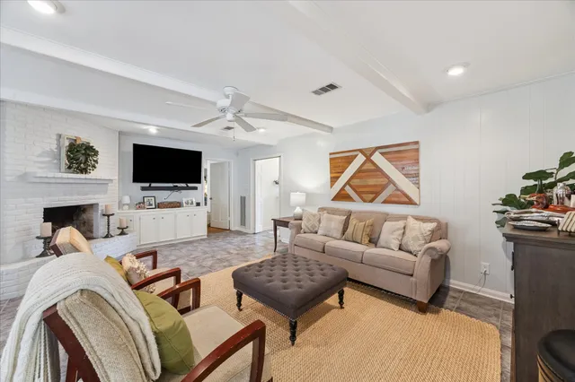a living room with furniture a flat screen tv and a fireplace