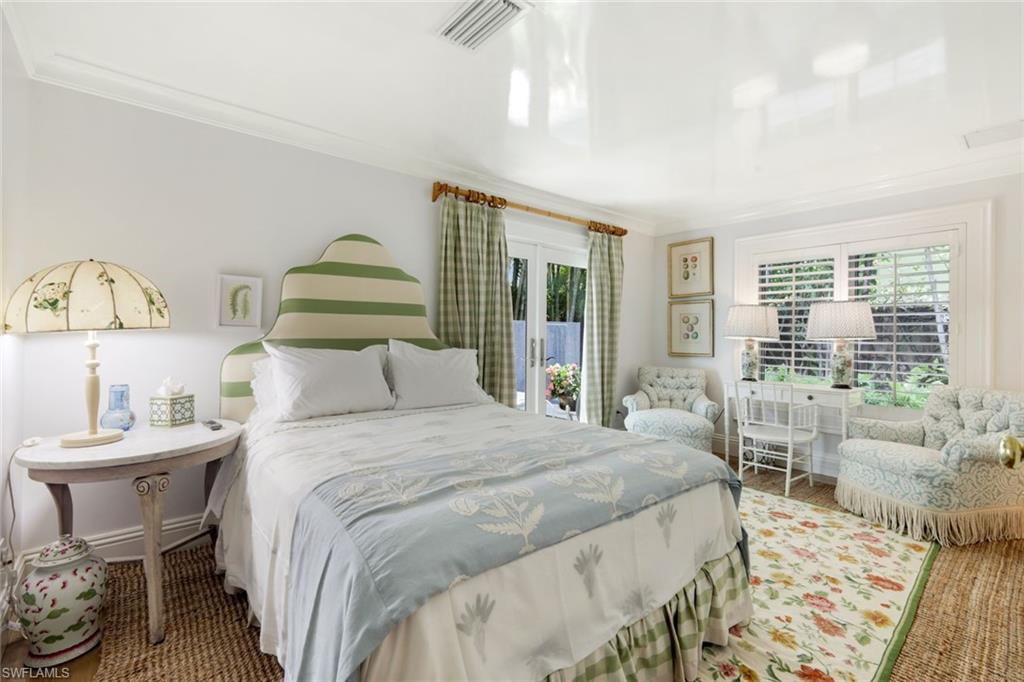 295 6th Street North Naples, FL 34102 - Photo 19 of 32 a bedroom with a bed and a table
