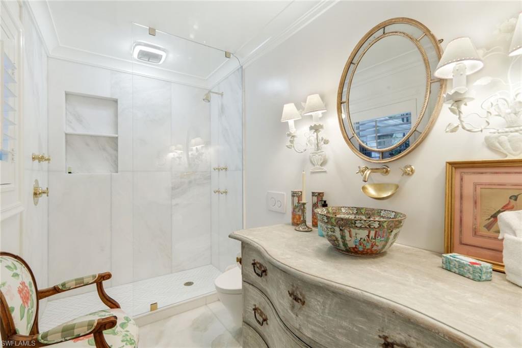 295 6th Street North Naples, FL 34102 - Photo 21 of 32 a bathroom with a sink a mirror and a shower