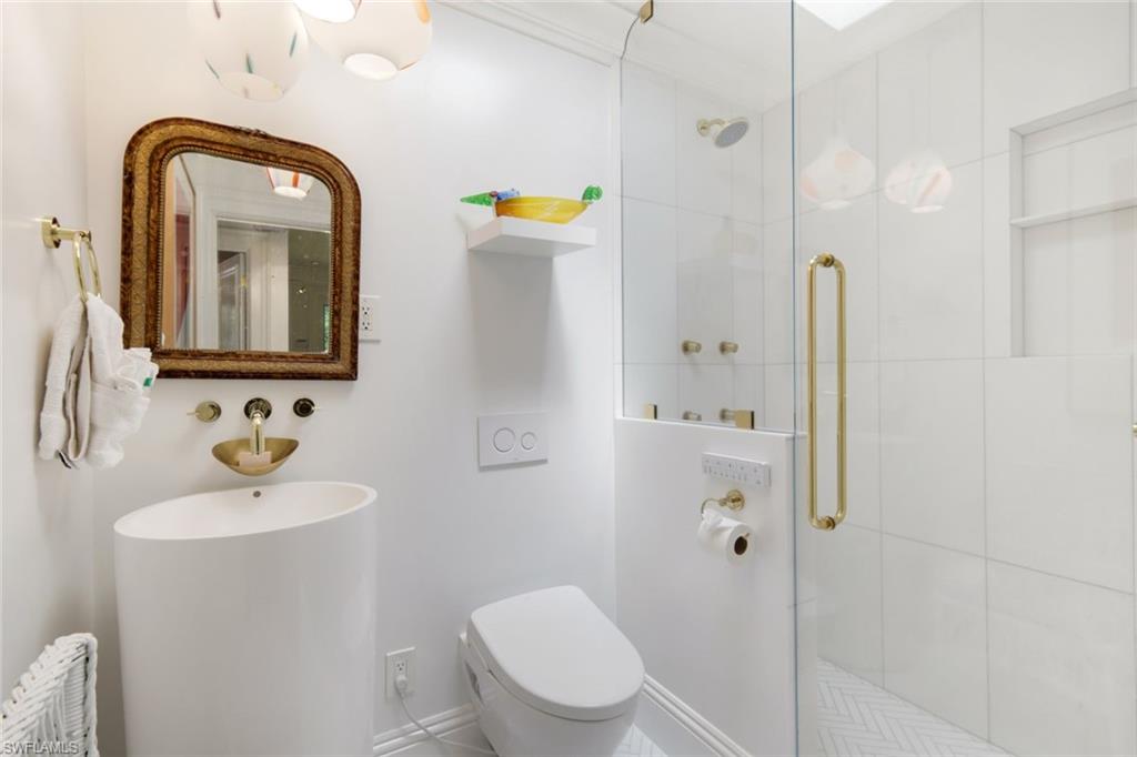 295 6th Street North Naples, FL 34102 - Photo 23 of 32 a bathroom with a toilet sink and mirror
