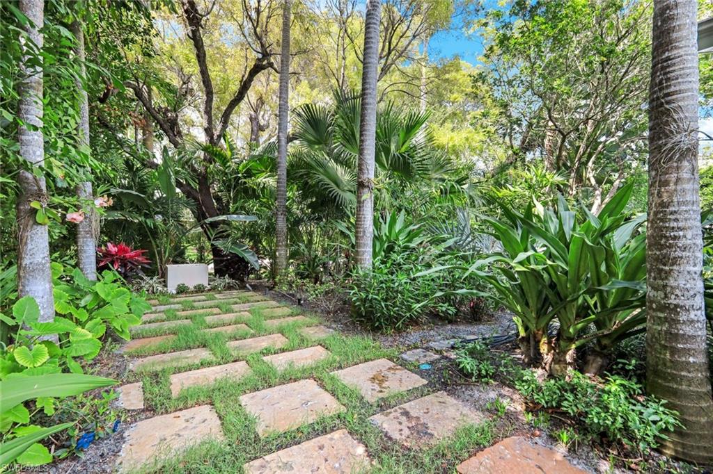 295 6th Street North Naples, FL 34102 - Photo 25 of 32 a backyard of a house with lots of green space and a fountain