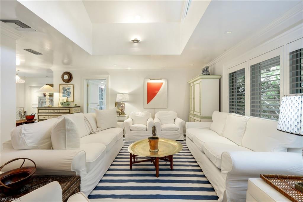 295 6th Street North Naples, FL 34102 - Photo 4 of 32 a living room with furniture a rug potted plant and a large window