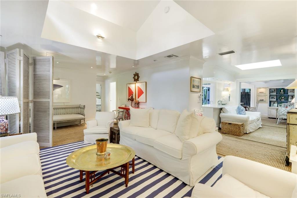 295 6th Street North Naples, FL 34102 - Photo 5 of 32 a living room with furniture and a dining table with wooden floor