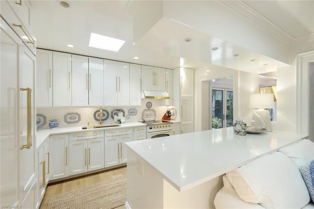 295 6th Street North Naples, FL 34102 - Photo 9 of 32 a kitchen with stainless steel appliances kitchen island granite countertop a sink and cabinets