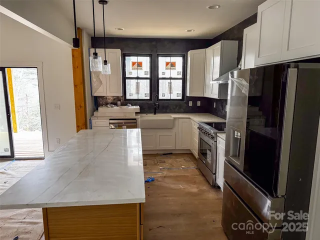 a kitchen with granite countertop a refrigerator stove and sink