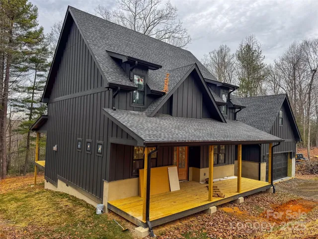 a view of house with large trees and wooden fence