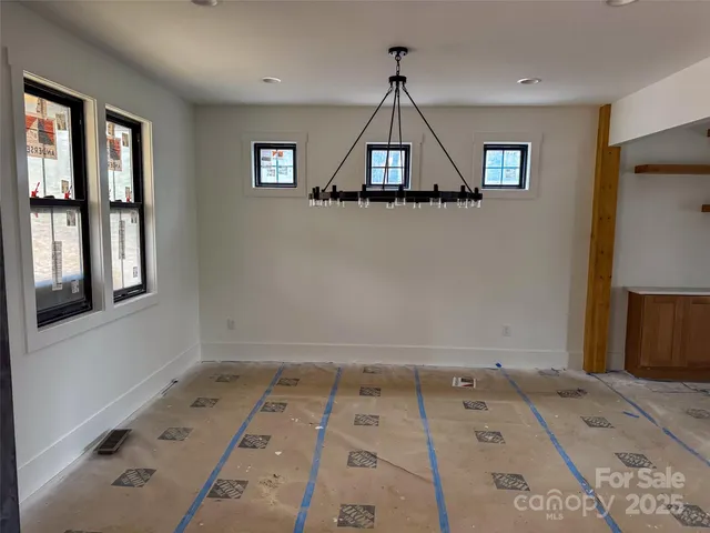 a view of a hallway with a window and chandelier