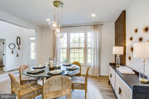 a kitchen with kitchen island a dining table chairs stainless steel appliances and cabinets