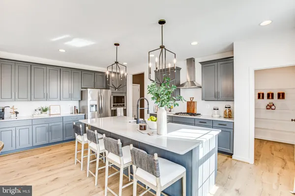 a view of a dining room and livingroom with furniture wooden floor a chandelier