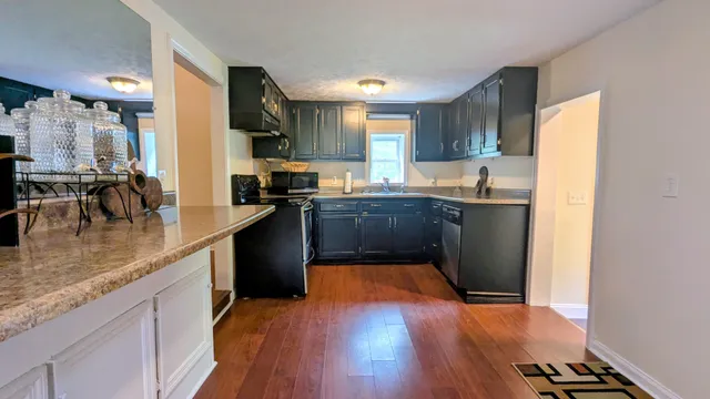 a kitchen with stainless steel appliances granite countertop a sink stove and wooden cabinets