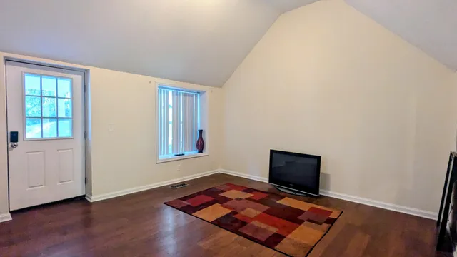 a living room with hard wood floor and a window