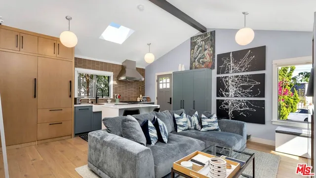 a living room with furniture a chandelier and a large mirror