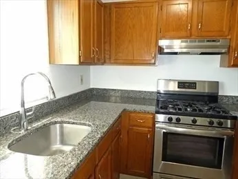 a kitchen with stainless steel appliances granite countertop a stove a sink and a refrigerator