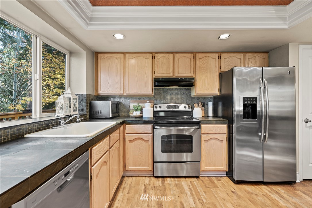 4321 234th Place Southeast Bothell, WA 98021 - Photo 7 of 25 a kitchen with a stove a sink and a refrigerator