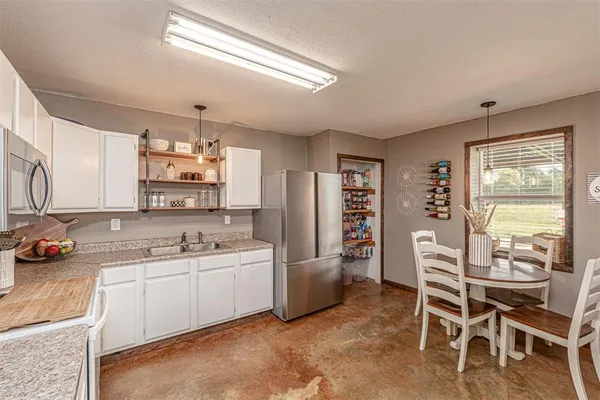 a kitchen with a sink a counter top space appliances and cabinets