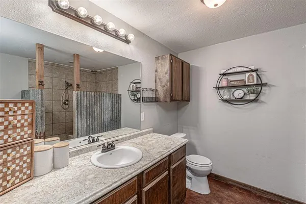 a bathroom with a granite countertop sink toilet and a mirror