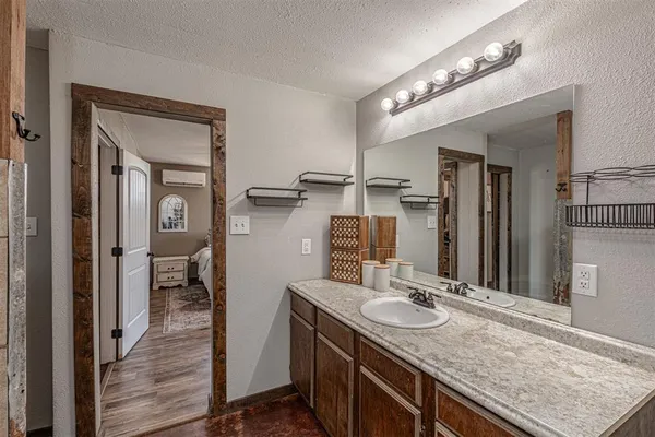 a bathroom with a granite countertop sink a mirror and a shower