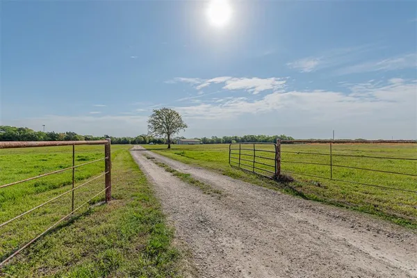 a view of a yard with wooden fence