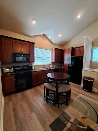 a kitchen with a refrigerator cabinets and a wooden floor